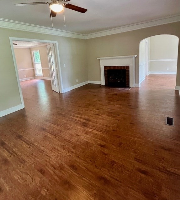 1555 Wells Dr, Columbus, GA 31906 - unfurnished living room featuring a ceiling fan, wood finished floors, crown molding, arched walkways, and a brick fireplace