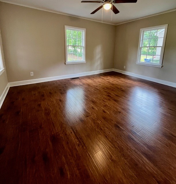 1555 Wells Dr, Columbus, GA 31906 - empty room with crown molding, plenty of natural light, ceiling fan, and dark wood-style floors