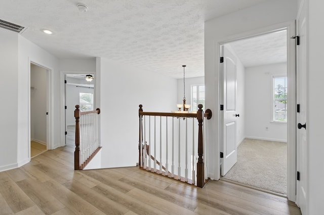 4685 Ivy Patch Dr, Fortson, GA 31808 - hall featuring an upstairs landing, a textured ceiling, light wood-style flooring, and baseboards