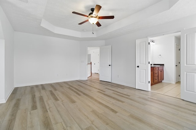 4685 Ivy Patch Dr, Fortson, GA 31808 - unfurnished bedroom featuring light wood-style flooring, a raised ceiling, baseboards, and ensuite bath