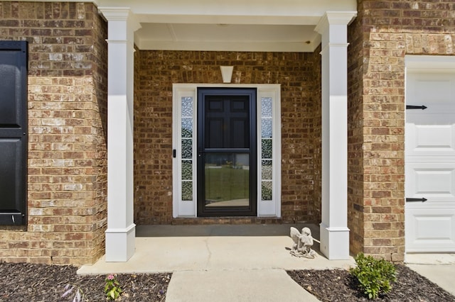 4685 Ivy Patch Dr, Fortson, GA 31808 - doorway to property featuring brick siding, a porch, and a garage