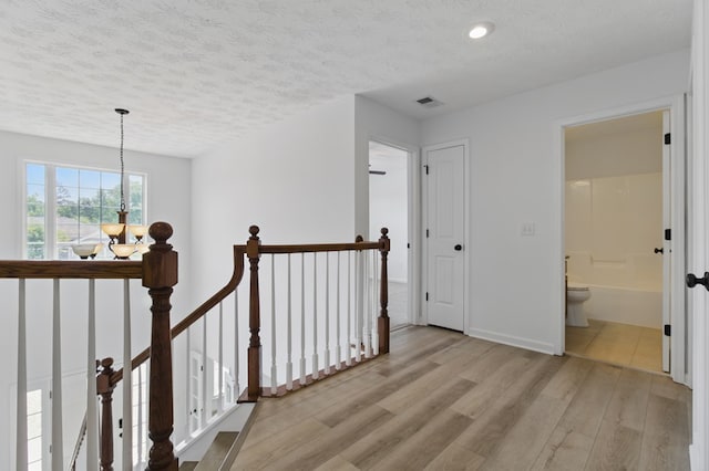 4685 Ivy Patch Dr, Fortson, GA 31808 - hall with an upstairs landing, light wood-style floors, a textured ceiling, a chandelier, and recessed lighting