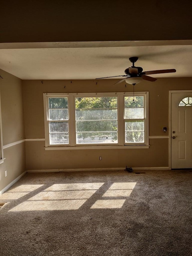 unfurnished room featuring ceiling fan and carpet
