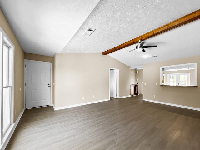 unfurnished living room with vaulted ceiling with beams, visible vents, a textured ceiling, wood finished floors, and baseboards