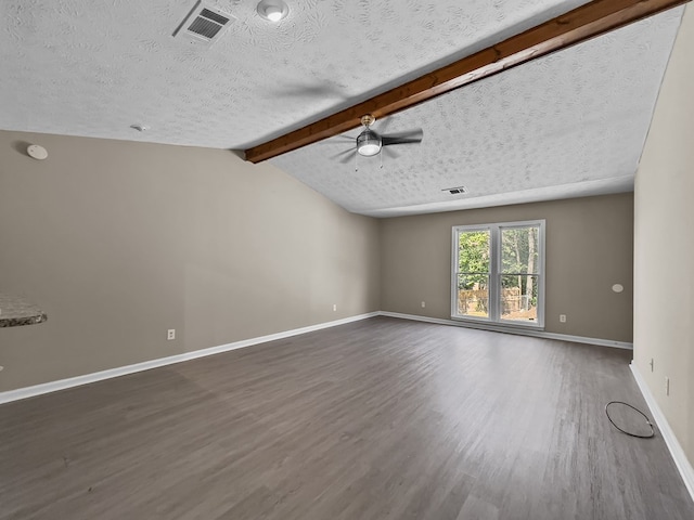 empty room with a textured ceiling, vaulted ceiling with beams, dark wood-style flooring, and baseboards