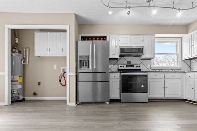 kitchen featuring stainless steel appliances, gas water heater, and white cabinets