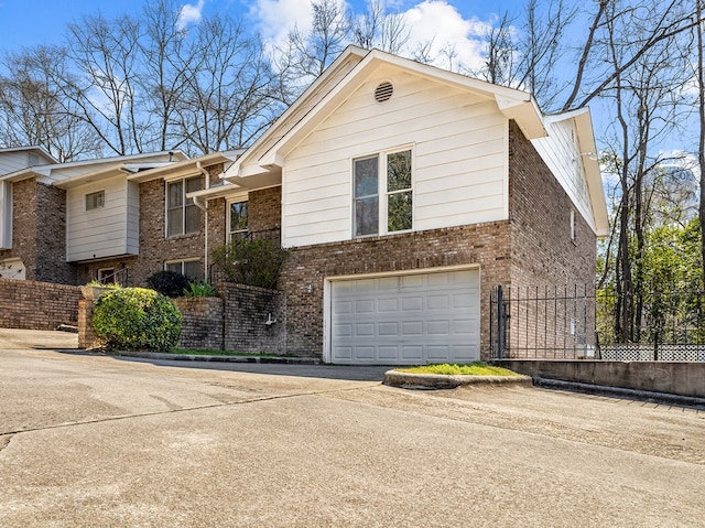 view of front of property with driveway, a garage, fence, and brick siding