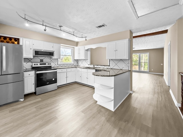 kitchen with decorative backsplash, appliances with stainless steel finishes, light wood-style floors, white cabinetry, and open shelves