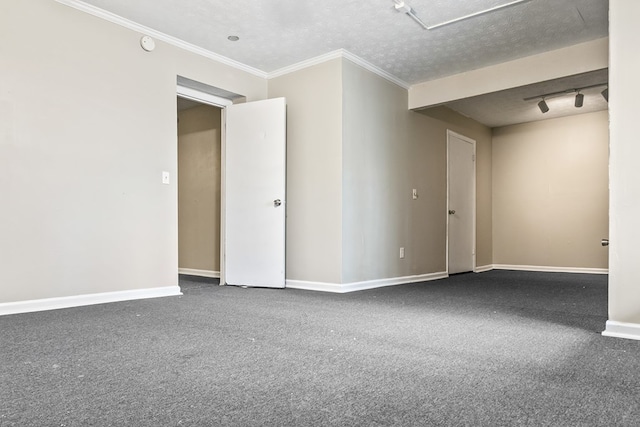 carpeted spare room with rail lighting, crown molding, baseboards, and a textured ceiling