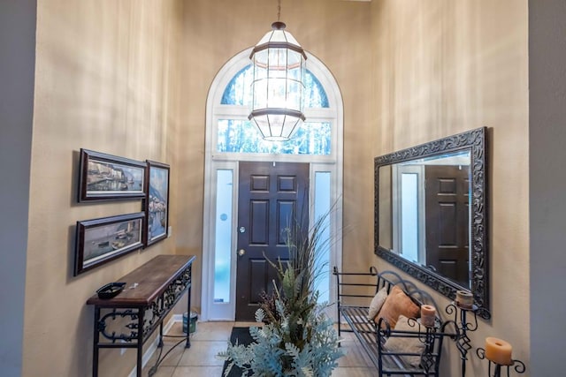 entryway with tile patterned flooring and a towering ceiling