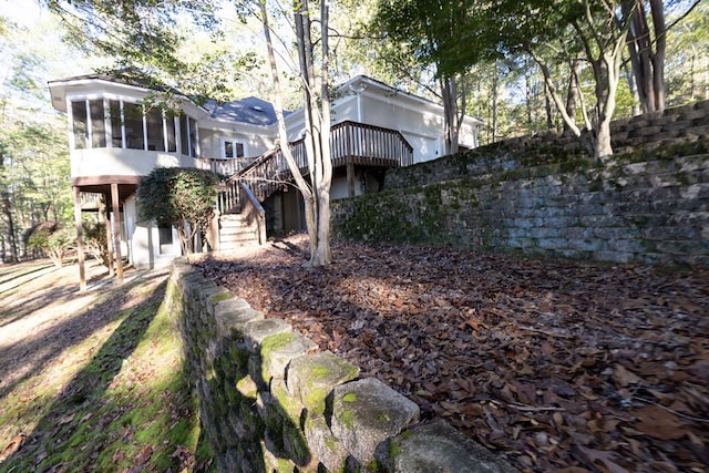 exterior space with stairs, a deck, and a sunroom