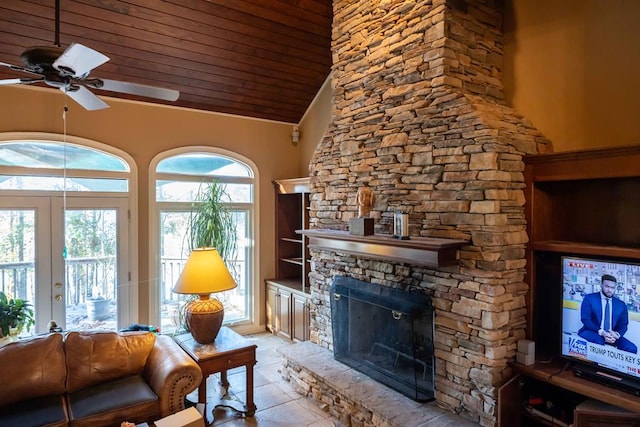 living area featuring light tile patterned floors, a ceiling fan, lofted ceiling, a stone fireplace, and wood ceiling