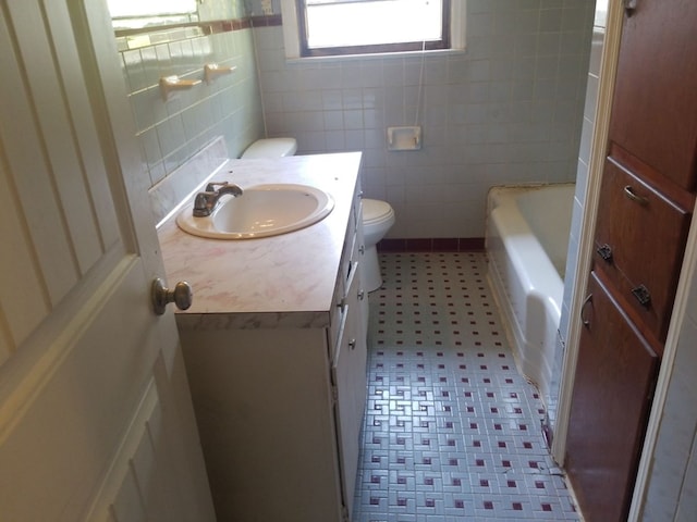 bathroom with vanity, toilet, and a bathing tub