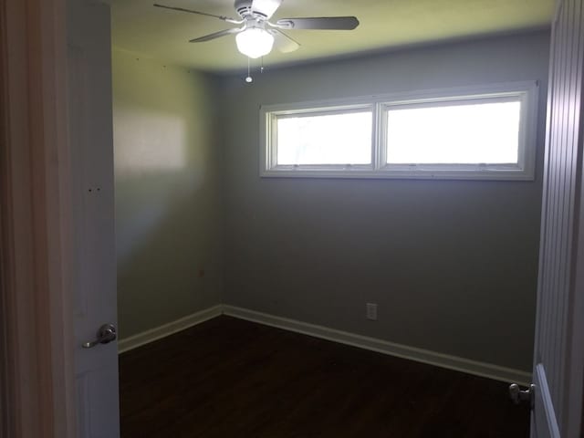 spare room with ceiling fan and dark wood-type flooring