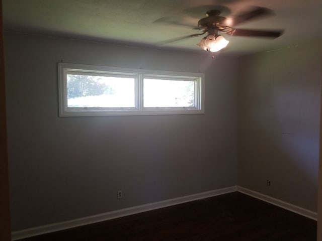 spare room featuring ceiling fan and dark wood-type flooring