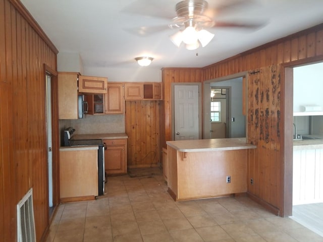 kitchen with range with electric cooktop, ceiling fan, tasteful backsplash, kitchen peninsula, and wood walls