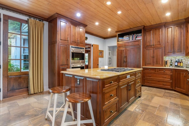 kitchen featuring stainless steel appliances, wood ceiling, backsplash, a center island, and stone tile flooring