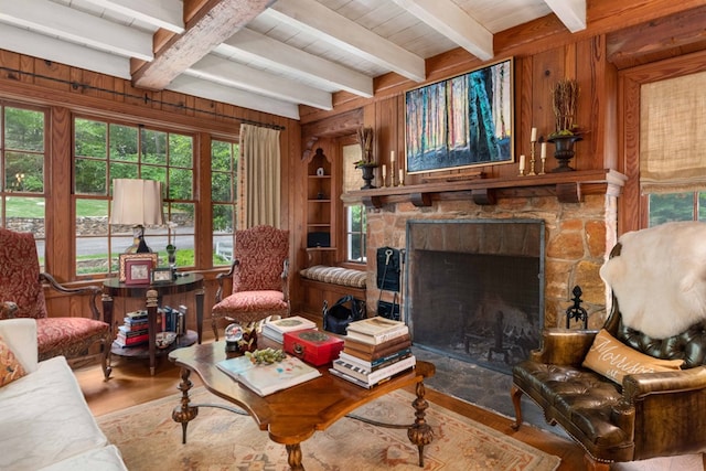 living area with a fireplace, wood walls, and wood finished floors