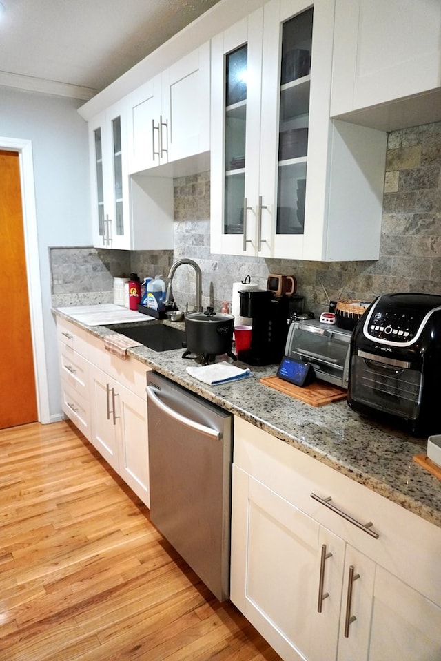 404 19th Ave, Phenix City, AL 36869 - kitchen with dishwasher, decorative backsplash, light wood-style flooring, white cabinetry, and ornamental molding