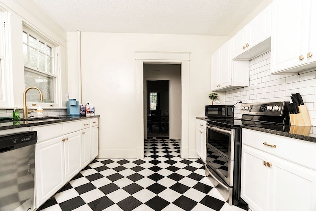 1240 Peacock Ave, Columbus, GA 31906 - kitchen with appliances with stainless steel finishes, light floors, white cabinets, and tasteful backsplash