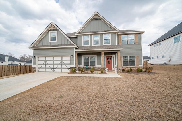 craftsman inspired home featuring an attached garage, board and batten siding, fence, stone siding, and driveway