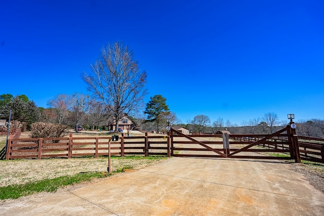 view of patio featuring a gate, a rural view, and fence