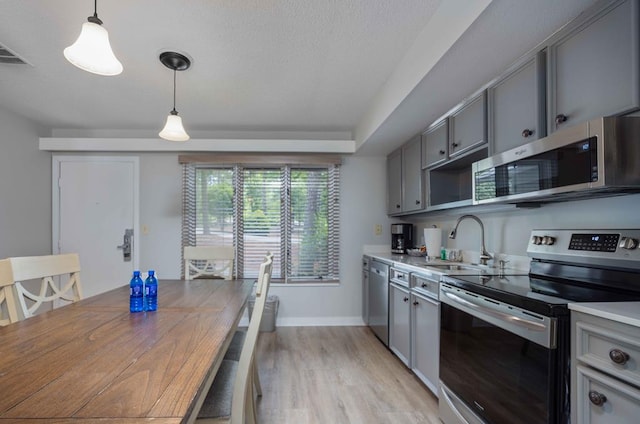 2387 Cedar Ln, Pine Mountain, GA 31822 - kitchen featuring appliances with stainless steel finishes, gray cabinetry, a sink, light wood-type flooring, and a textured ceiling