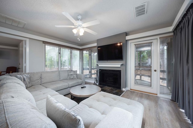 2387 Cedar Ln, Pine Mountain, GA 31822 - living area featuring a tile fireplace, a ceiling fan, wood finished floors, a textured ceiling, and baseboards