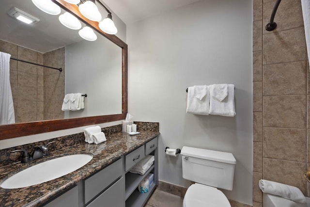 2387 Cedar Ln, Pine Mountain, GA 31822 - bathroom featuring a tile shower, toilet, vanity, baseboards, and tile patterned flooring