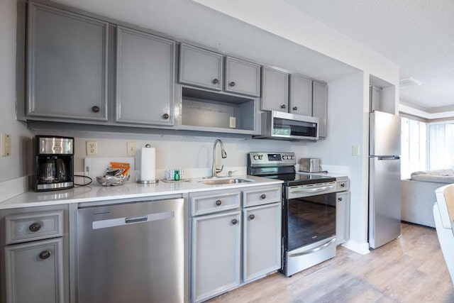 2387 Cedar Ln, Pine Mountain, GA 31822 - kitchen with appliances with stainless steel finishes, a sink, gray cabinetry, light wood finished floors, and light countertops