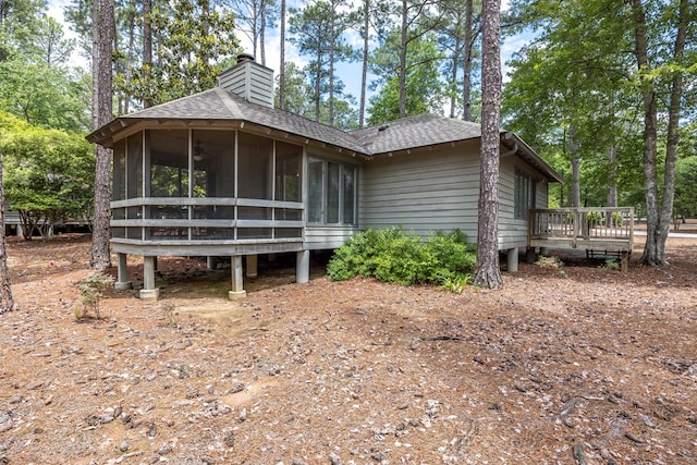 2387 Cedar Ln, Pine Mountain, GA 31822 - view of home's exterior featuring roof with shingles, a sunroom, a chimney, a wooden deck, and view of scattered trees