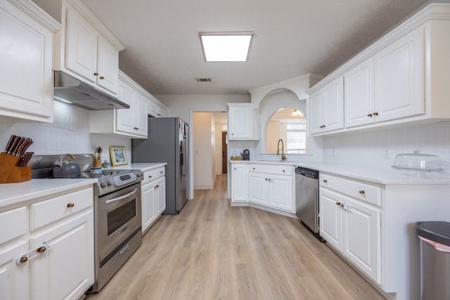 3022 Thornberry Cir, Phenix City, AL 36867 - kitchen featuring appliances with stainless steel finishes, under cabinet range hood, a sink, light wood-type flooring, and white cabinetry