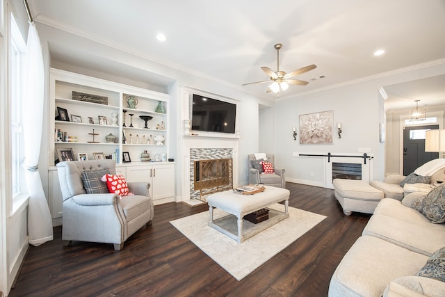 living room featuring crown molding, ceiling fan, dark hardwood / wood-style flooring, and a tile fireplace