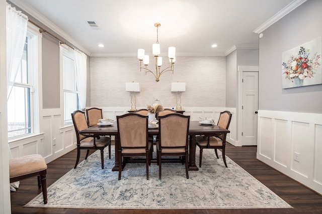 dining area with dark hardwood / wood-style flooring, ornamental molding, and a chandelier