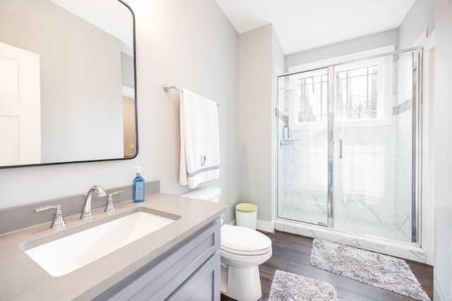 bathroom with vanity, wood-type flooring, a shower with door, and toilet