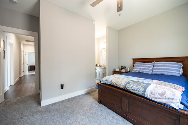 carpeted bedroom with ensuite bath and ceiling fan