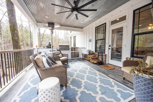 sunroom with ceiling fan and wooden ceiling