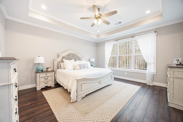 bedroom featuring dark hardwood / wood-style flooring, ornamental molding, and a raised ceiling