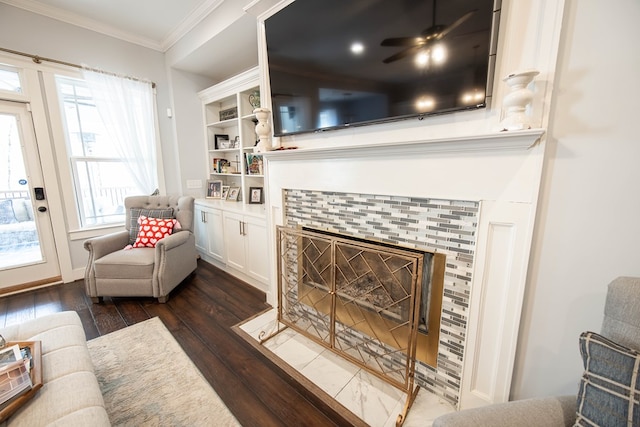 living room with dark wood-type flooring, a fireplace, and ornamental molding