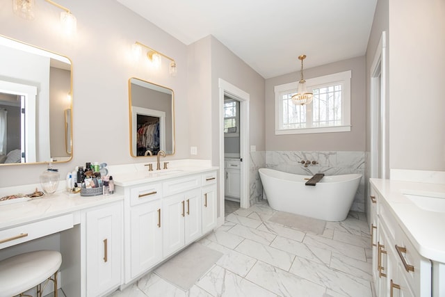 bathroom with vanity, a tub, and tile walls