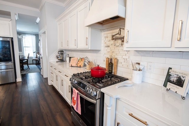 kitchen featuring custom exhaust hood, gas range, white cabinetry, crown molding, and tasteful backsplash