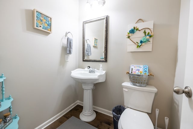 bathroom featuring toilet, baseboards, and wood finished floors