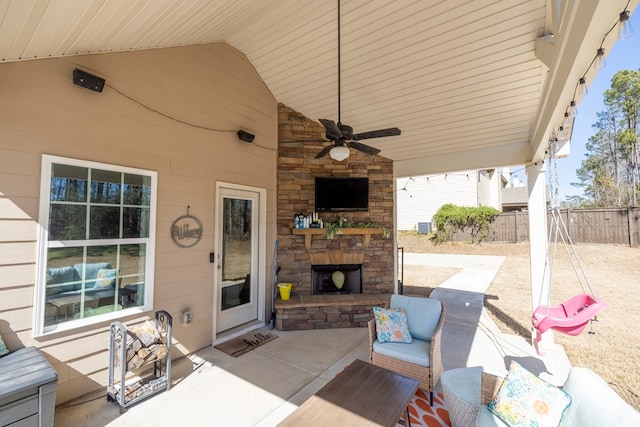 view of patio / terrace with ceiling fan, an outdoor living space with a fireplace, and fence