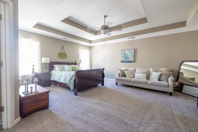 carpeted bedroom with multiple windows, visible vents, and a raised ceiling