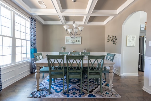 dining room with dark wood-type flooring, arched walkways, visible vents, and beamed ceiling