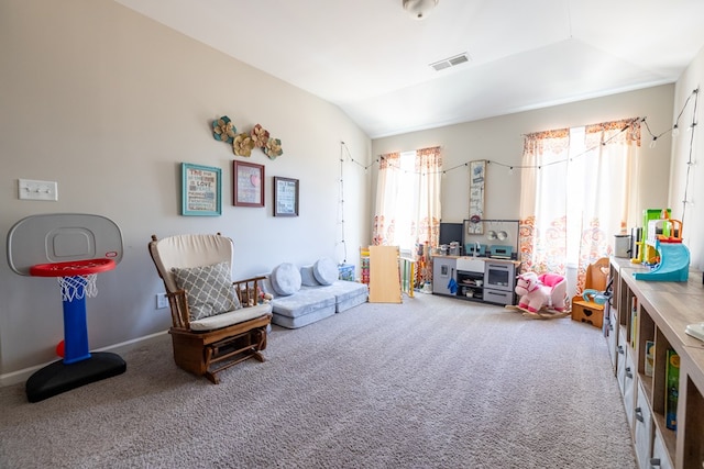 living area featuring vaulted ceiling, carpet flooring, visible vents, and baseboards