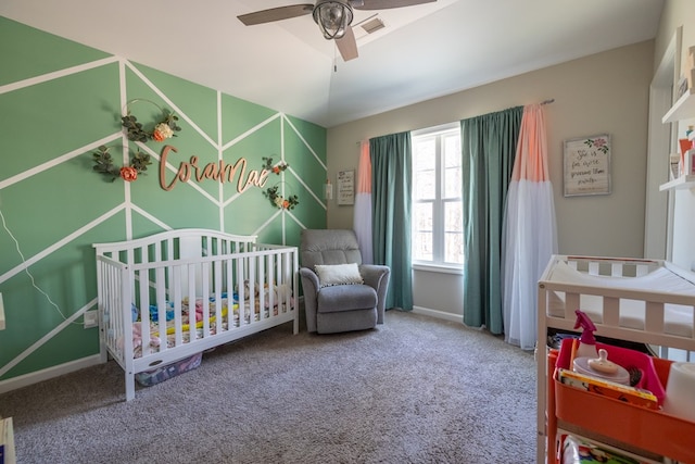 carpeted bedroom with a nursery area, ceiling fan, visible vents, and baseboards