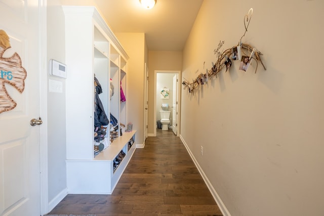 mudroom featuring dark wood finished floors and baseboards