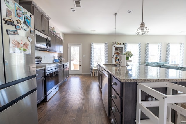 kitchen with visible vents, dark wood finished floors, appliances with stainless steel finishes, dark brown cabinets, and a sink