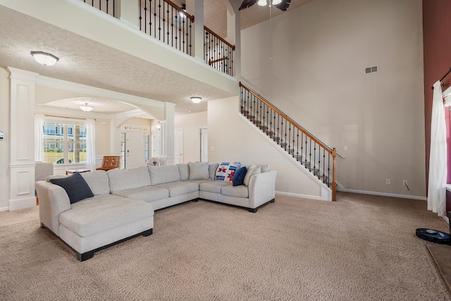 living room with visible vents, baseboards, stairs, carpet flooring, and arched walkways